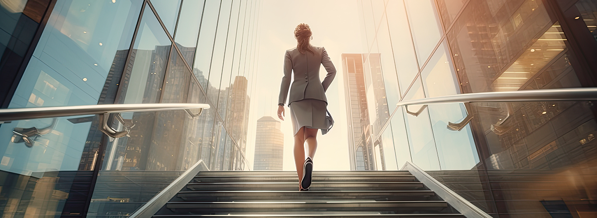 Woman walking up stairs into city street.
