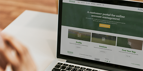 Man on Advanced Turf Solution's B2B portal homescreen on a laptop.